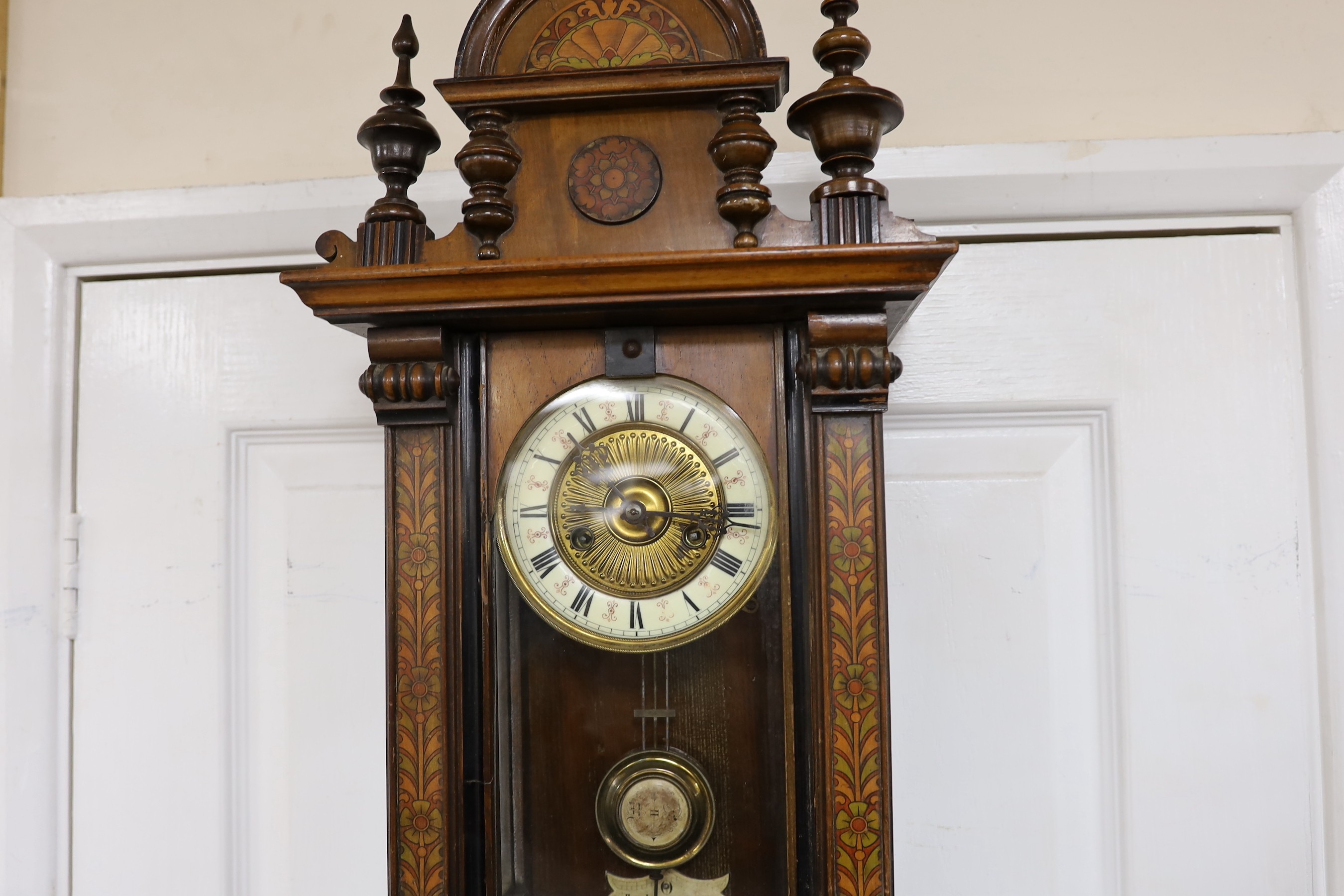 A small 19th century German wall clock with pendulum, 80cm long
